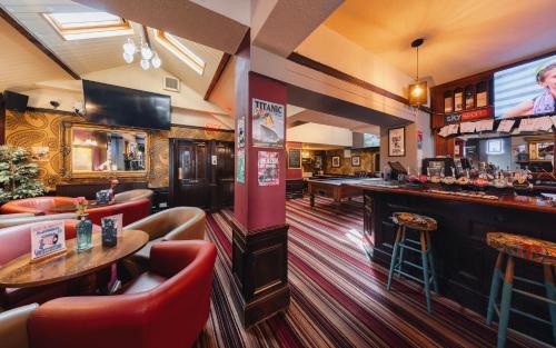 a bar in a restaurant with red chairs at The Grapes Pub in Southampton