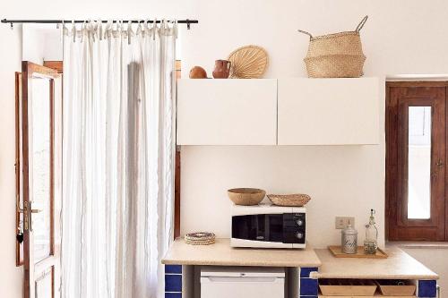 eine Küche mit einem Tisch und einer Mikrowelle in der Unterkunft La Ripa-apartment on the cliff edge in Peschici