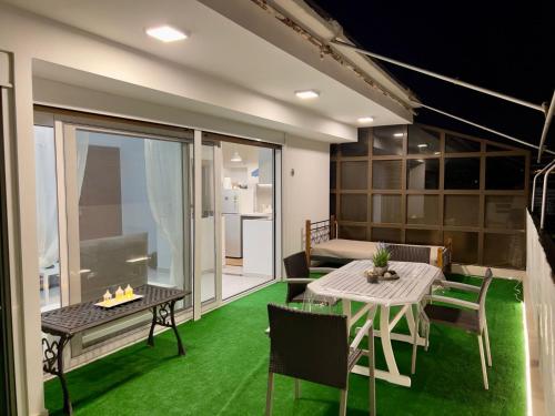 a room with a table and chairs and a balcony at Terrace Garden Close To Sea in Athens