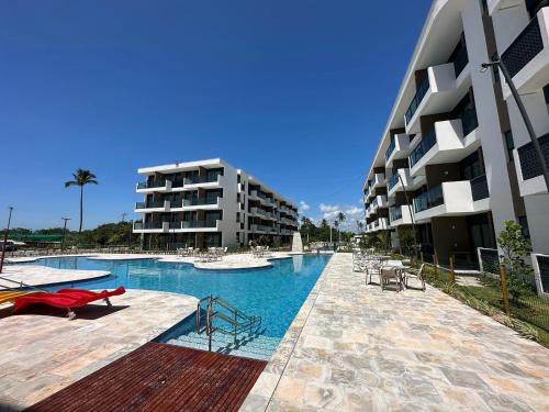 ポルト・デ・ガリーニャスにあるMakia Beach Muro Alto-Flat 02 Mahina Térreo Frente Piscinaの建物の隣にある大きなプール