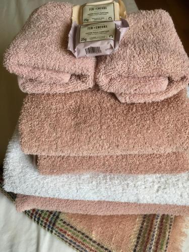 une pile de serviettes roses assises sur un lit dans l'établissement Studio 6, à Paris