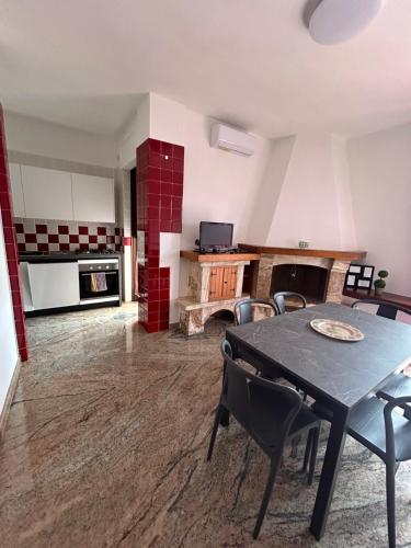 Una cocina con una mesa y sillas en una habitación. en Casa vacanza Largo Pozzi, en Turi