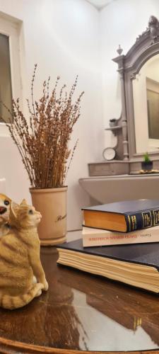 une pile de livres et une figurine de chat sur une table dans l'établissement T2-Cozy appartement près de Bordeaux, à Montussan