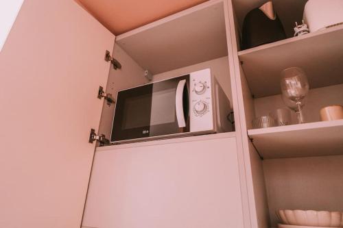 - une cuisine avec un four micro-ondes dans une armoire blanche dans l'établissement Farniente - Studio neuf climatisé - Parking, à Roquefort-la-Bédoule