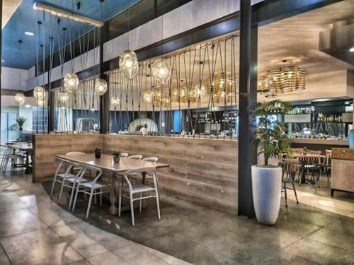 a restaurant with a table and chairs and a bar at The Blyde Bliss in Pretoria