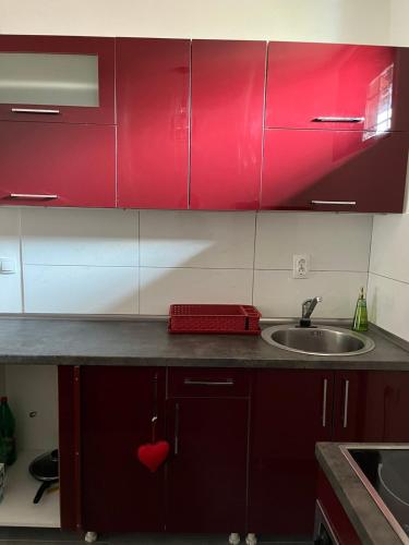 a kitchen with red cabinets and a sink at Miljaca in Pirot