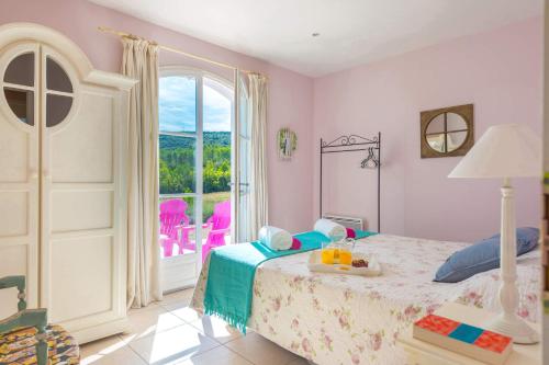 une chambre avec un lit et une grande fenêtre dans l'établissement Villa La Pastorale by Villa Plus, au Cannet-des-Maures