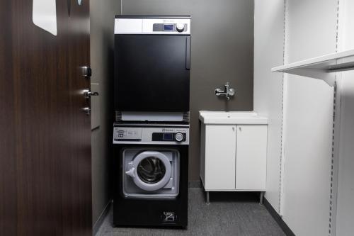 a washer and dryer in a small bathroom at Comfort Hotel Kristiansand in Kristiansand