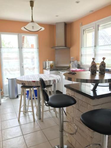 une cuisine avec une table et quelques chaises dans l'établissement La Josettine Mont-Saint-Michel, à Champcey