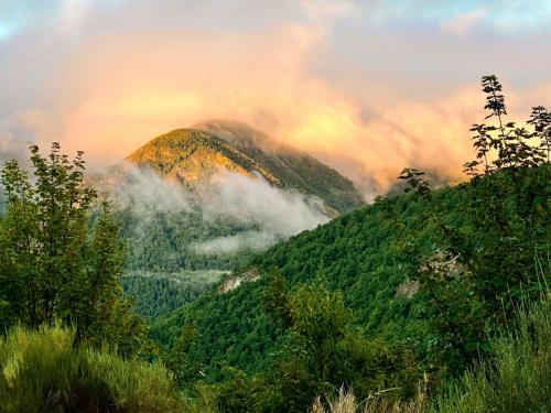 a mountain covered in mist and clouds in the mountains at Hotel rural La Campanona in Villager de Laciana