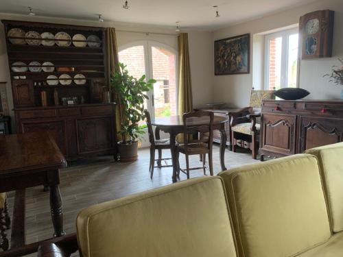 un salon avec un canapé, une table et des chaises dans l'établissement Maison de campagne, à Saint-Étienne-de-Vicq