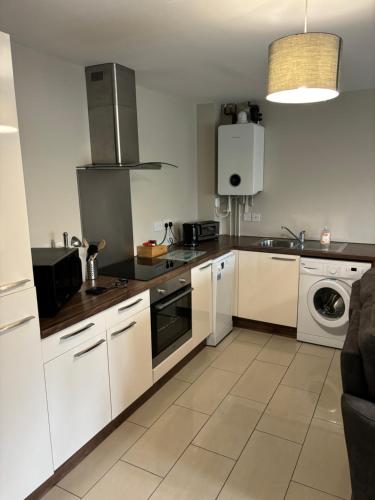 a kitchen with white cabinets and a stove top oven at Two Bedrooms Two Bathrooms and Private Parking Rugby in Rugby
