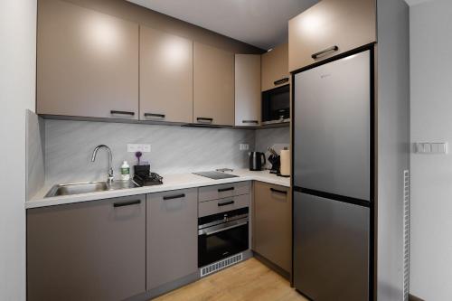 a kitchen with white cabinets and a stainless steel refrigerator at Apartmány Štěpánovice in České Budějovice