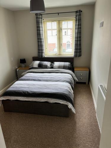 ラグビーにあるTwo Bedrooms Two Bathrooms and Private Parking Rugbyの窓のある大きなベッドのある寝室