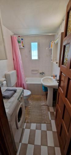 a bathroom with a tub and a sink and a toilet at Perithia Cottage in Perítheia