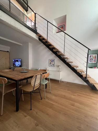 une salle à manger avec une table et un escalier dans l'établissement Loft entièrement rénové, à Collioure