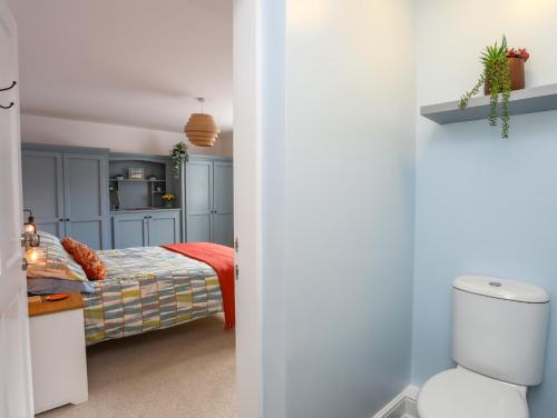 a bedroom with a bed with blue cabinets at 1 Tyn Y Gongl Cottage in Beaumaris