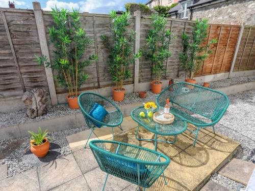a patio with a table and chairs and plants at 1 Tyn Y Gongl Cottage in Beaumaris