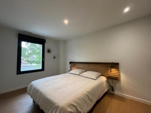 a bedroom with a large bed and a window at Villas-des-oyats - Arena - 8 personnes climatisée piscine chauffée in Seignosse