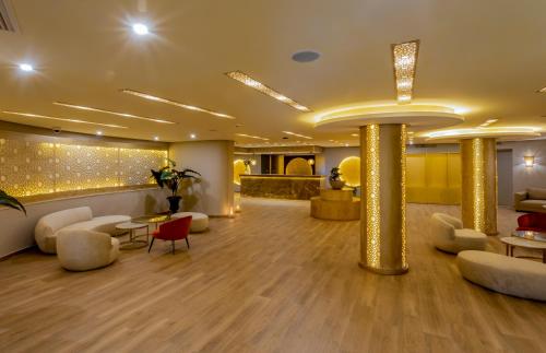 a lobby with couches and tables and gold pillars at Royal Tulip Korbous Bay Thalasso & Springs in Qurbuş