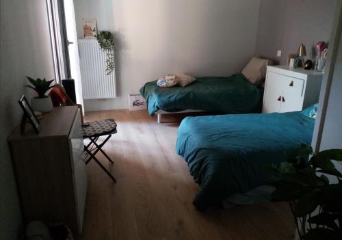 une petite chambre avec deux lits et une table dans l'établissement Gare centre ville d'Arcachon, à Arcachon