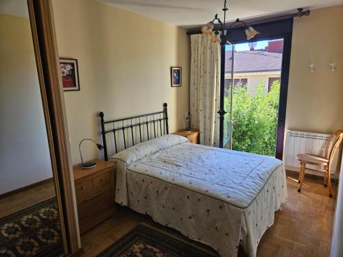 a bedroom with a bed and a large window at Apartamento Miravalles in Muros de Nalón