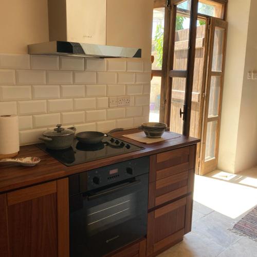 a kitchen with a stove with three pots on it at Levanda House - Traditional House in Vasa Kilaniou