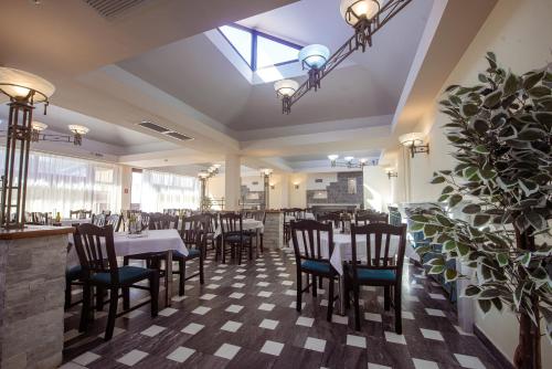 a restaurant with tables and chairs in a room at Hotel Doina in Neptun