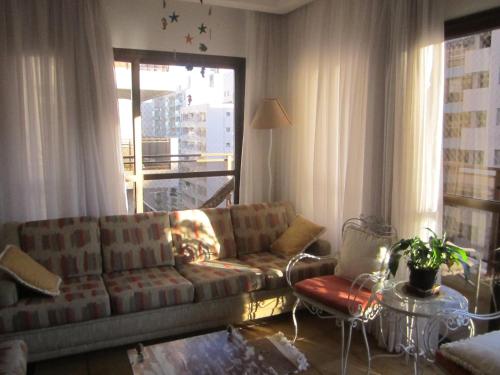 a living room with a couch and a window at Apartamento Vista Mar - 2 Garagens in Guarujá