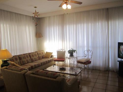 a living room with a couch and a table at Apartamento Vista Mar - 2 Garagens in Guarujá