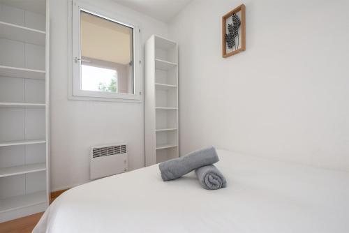 a white bedroom with a bed and a window at T2 Rangueil - Terrasse + 2 Parkings - 4 personnes in Toulouse
