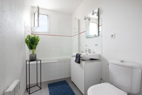 a white bathroom with a toilet and a sink at T2 Rangueil - Terrasse + 2 Parkings - 4 personnes in Toulouse