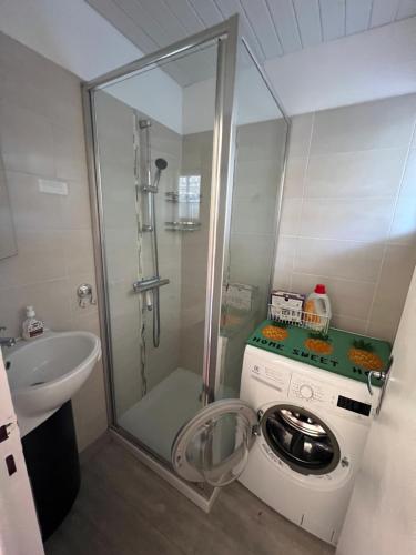 Un baño con lavadora y lavabo. en Bella Vista 42, T2 vue mer piscine Porticcio, en Porticcio