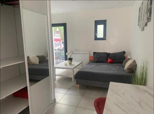 une chambre avec un lit et un miroir dans l'établissement Partie de villa moderne avec acces piscine, à Villeneuve