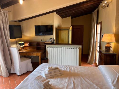 a bedroom with a bed and a desk and a television at Fattoria Casagrande in Rignano sullʼArno