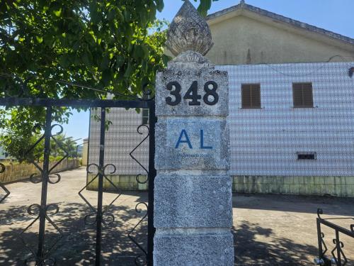 a stone monument with the number in front of a gate at CASA do MURO VELHO in Chão de Lamas