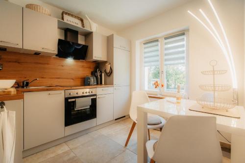 a kitchen with white cabinets and a table with chairs at PauliDrei in Leipzig