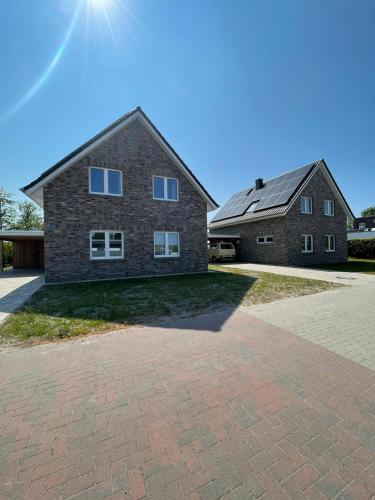 ein großes Backsteinhaus mit einer gemauerten Auffahrt in der Unterkunft Willi - Familienurlaub direkt am Deich in Butjadingen