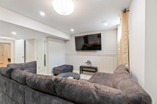 a living room with a large couch and a table at Cozy and Private Basement Suite with All Amenities in Carleton Place