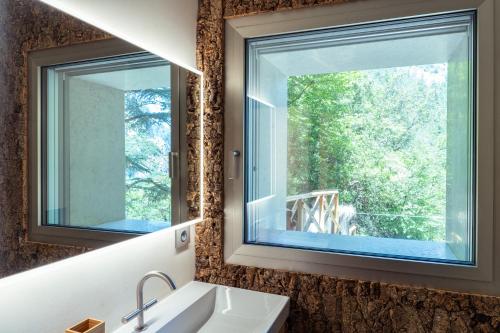 a bathroom with two windows and a sink at La Forestale Luxury Ecolodge B&B Primo Piano in Acqualagna