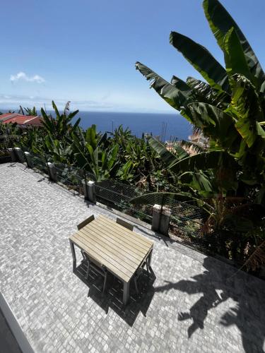 a wooden bench sitting on a patio overlooking the ocean at Lazareto 148 Hostel in Funchal