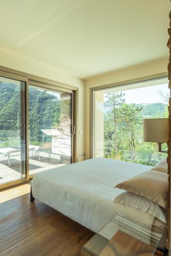 a bedroom with a large bed and a large window at La Forestale Luxury Ecolodge B&B Primo Piano in Acqualagna