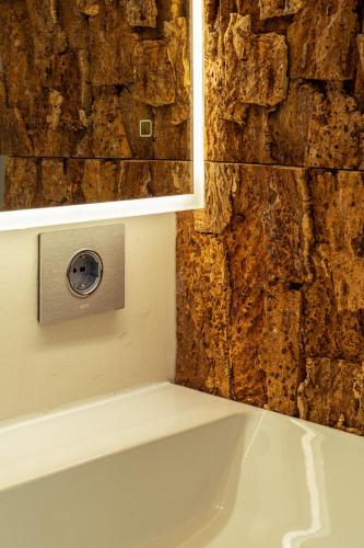 a bath tub in a bathroom with a stone wall at La Forestale Luxury Ecolodge B&B Primo Piano in Acqualagna