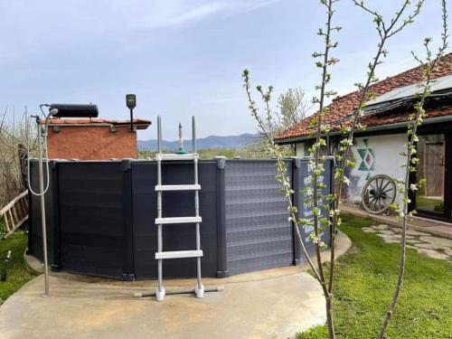 a ladder in front of a black fence at Къща за гости РАЙ 6човека in Boykovtsi