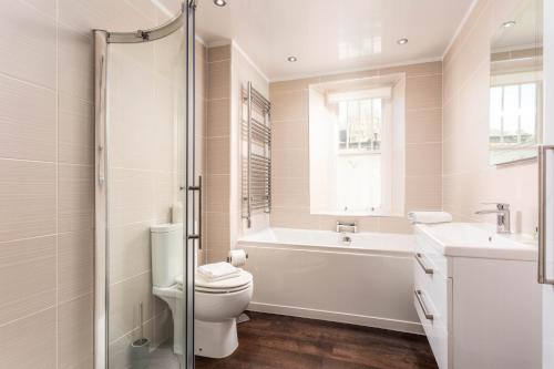 a bathroom with a tub and a toilet and a sink at Burnock Lodge with Hot Tub in Ayr