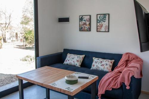 a living room with a blue couch and a table at Minicasas in Villa Ciudad Parque