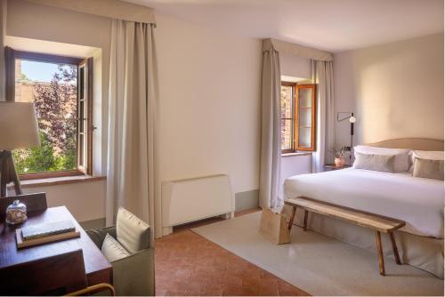 a hotel room with a bed and a desk and a window at Precise Tale Poggio Alla Sala in Montepulciano