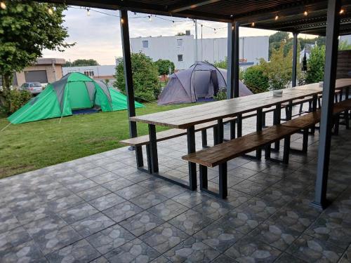 a picnic table and two tents on a patio at Hani's Partyhaus in Verl
