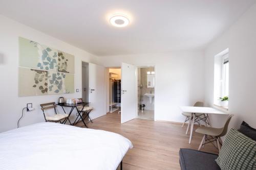 a bedroom with a white bed and a dining room at CHATA LESOVNA in Pec pod Sněžkou