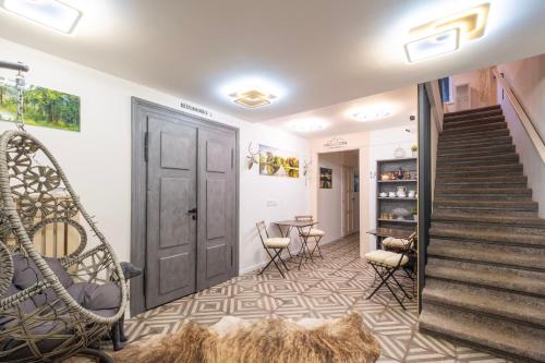 a room with a staircase and a door and chairs at CHATA LESOVNA in Pec pod Sněžkou